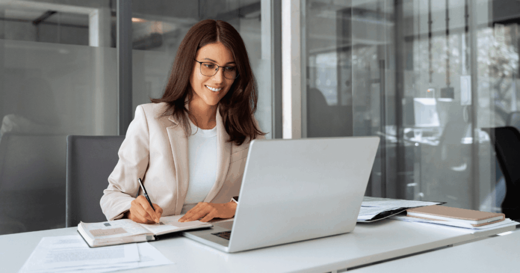 Profissional de finanças trabalhando no computador e analisando documentos para realizar a provisão de pagamentos em um ambiente de escritório.