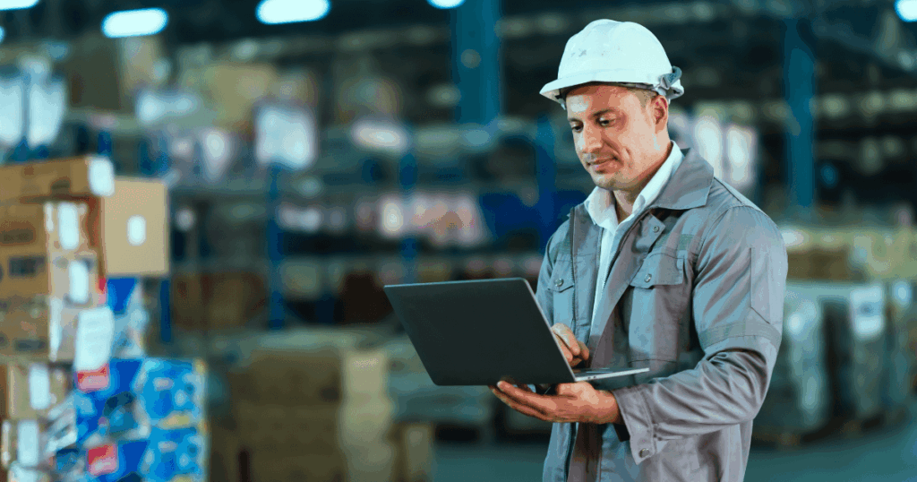 Profissional utilizando EPI com notebook em mãos analisando a capacidade produtiva