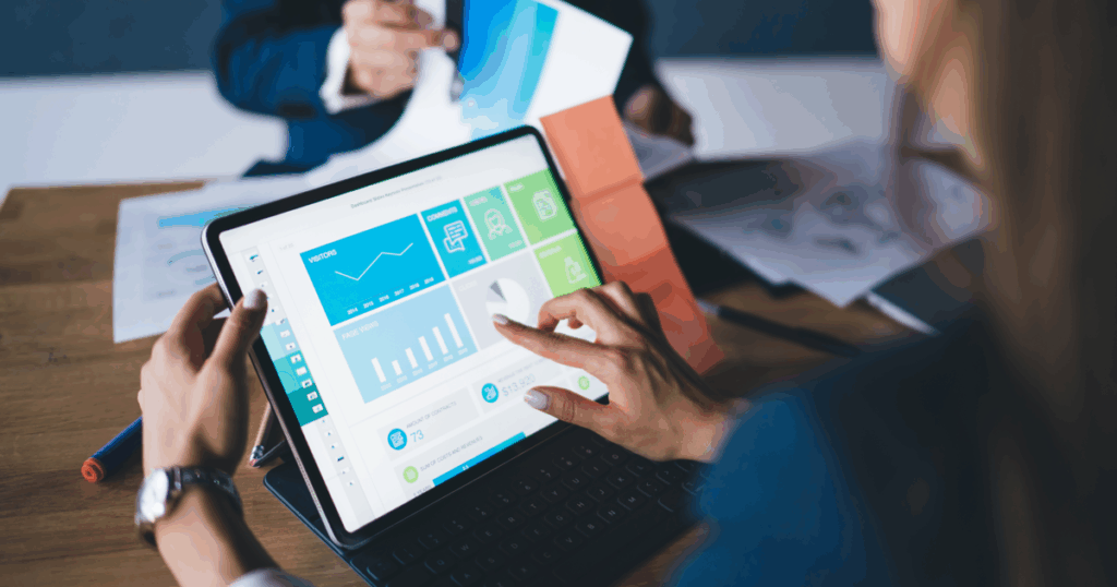 Uma mulher consultando, em seu tablet, dashboards de dados, no Business Intelligence disponível em seu sistema.