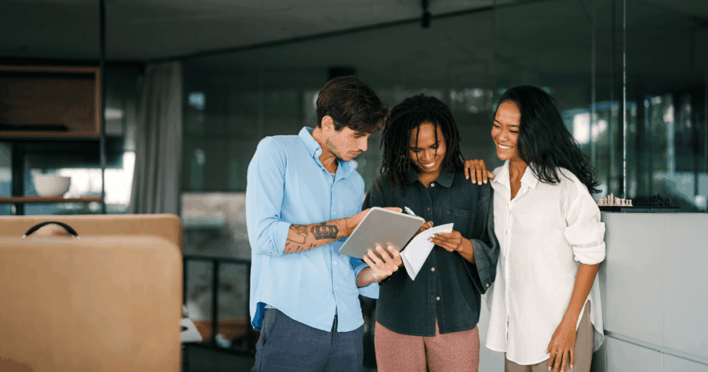 Profissionais discutindo um projeto em tablet em um ambiente corporativo, simbolizando a inovação aberta e colaboração