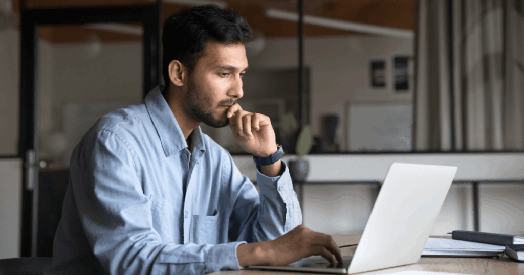Empresário analisando informações no notebook, representando o desenvolvimento e avaliação de um plano de negócios.