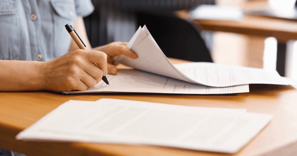 Profissional assinando documento, representando a gestão de contratos