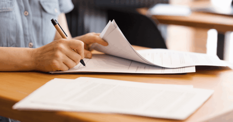 Profissional assinando documento, representando a gestão de contratos