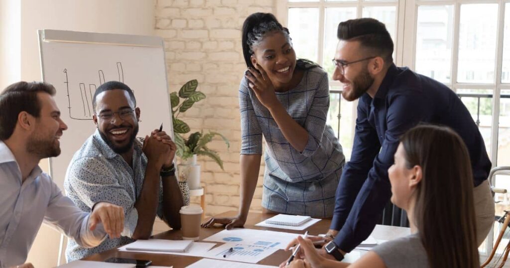 Equipe diversa em reunião estratégica colaborativa, analisando gráficos de desempenho com foco em aumentar a eficiência operacional no ambiente corporativo.