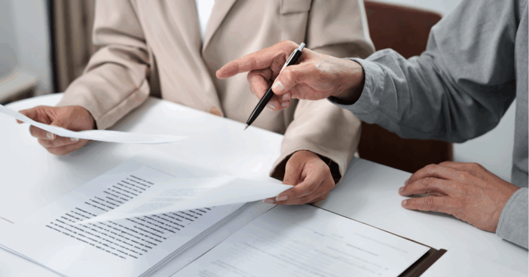 Duas mãos de profissionais segurando folhas e analisando informações da nova lei trabalhista