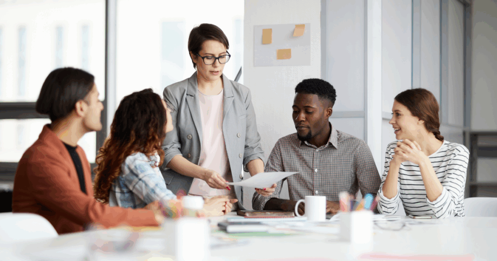 Pessoas em uma reunião conversando sobre o gerenciamento de projetos de uma empresa.