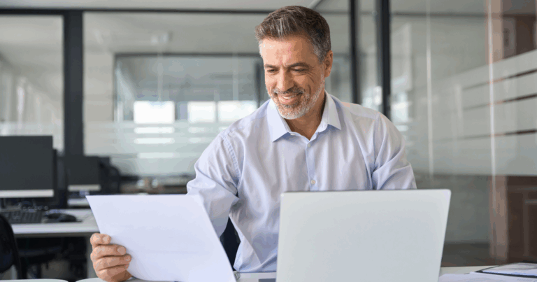 Homem analisando holerite em ambiente corporativo, conferindo detalhes do contracheque no escritório com apoio de notebook