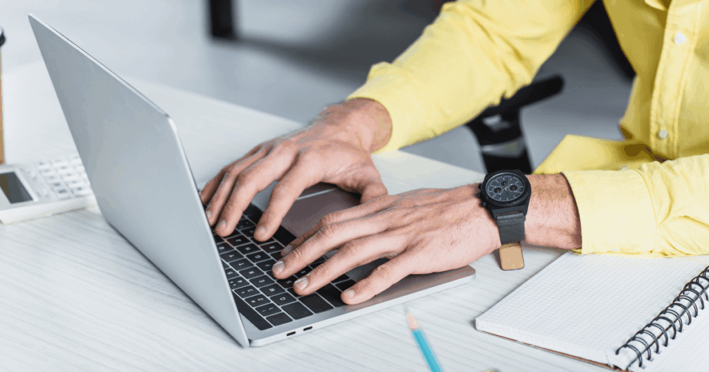 Pessoa digitando em notebook sobre IRPJ, com calculadora e caderno ao lado, representando análise e planejamento tributário empresarial.