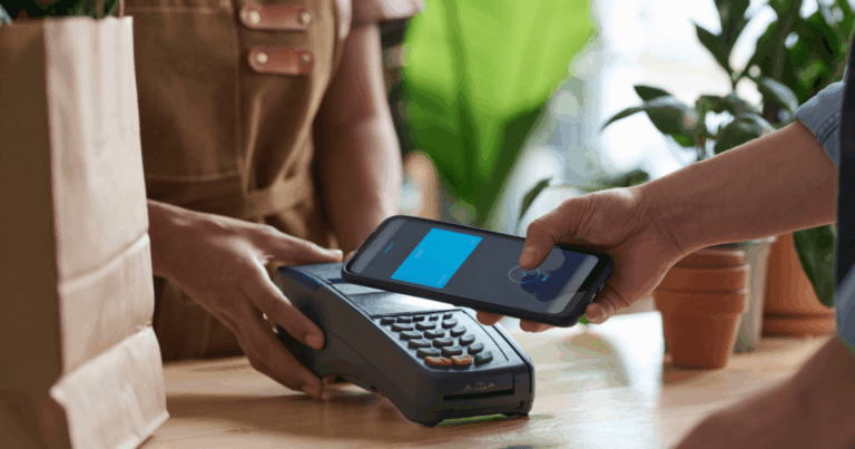 Pagamento por aproximação via smartphone em maquininha, representando soluções de Embedded Finance no varejo.