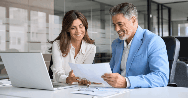 Dois profissionais em escritório analisando documentos juntos, representando a discussão sobre pró-labore em empresas.