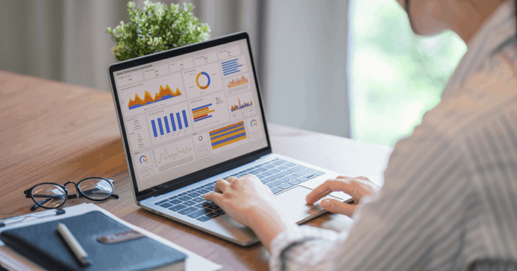 Profissional analisando gráficos e indicadores financeiros em dashboard no notebook, com foco no acompanhamento do lucro operacional da empresa.