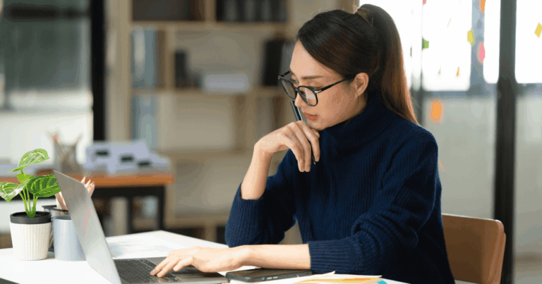 Profissional analisando informações fiscais no notebook em ambiente corporativo, representando estudos sobre substituição tributária e obrigações acessórias no sistema tributário brasileiro.