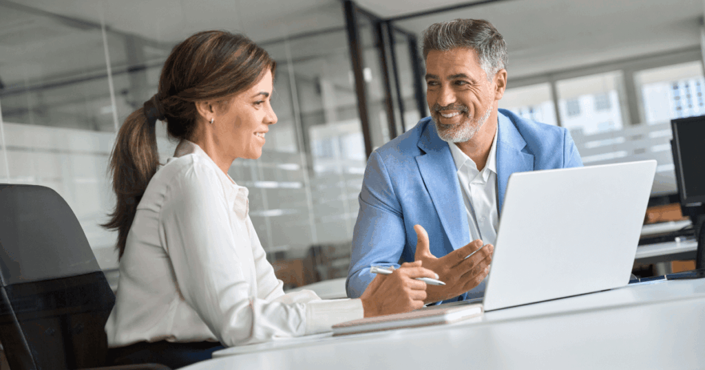 Profissionais do backoffice em reunião corporativa, analisando informações estratégicas no computador em ambiente de escritório moderno.