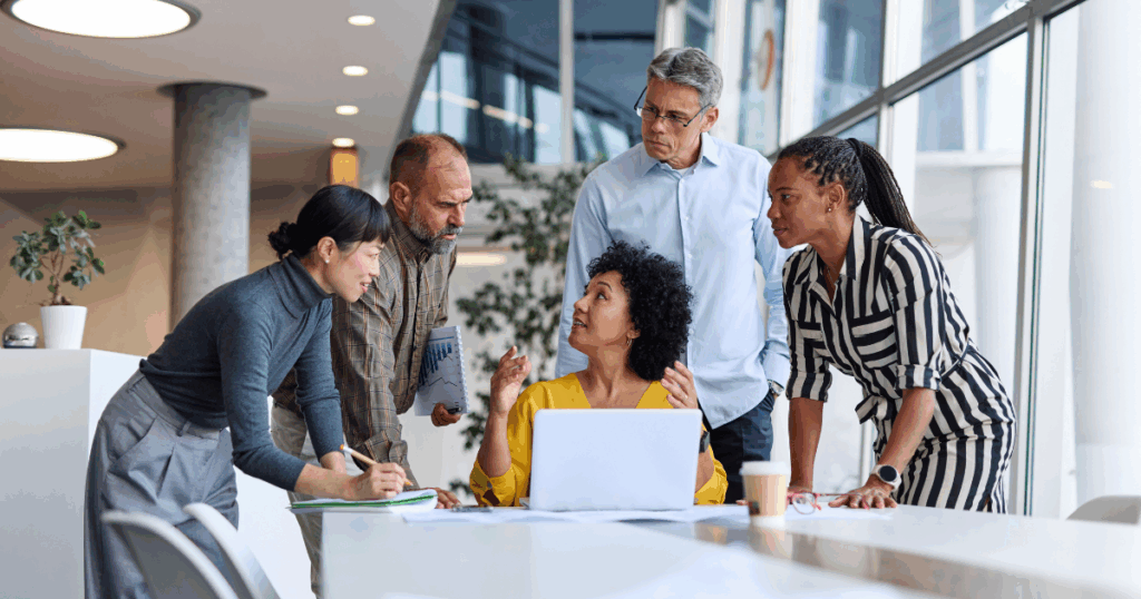 Equipe de profissionais reunida em reunião corporativa analisando informações e discutindo estratégias, representando o processo de tomada de decisão no ambiente empresarial.