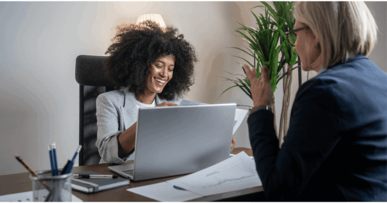 Consultoras em reunião de BPO financeiro, analisando relatórios e dados financeiros em ambiente corporativo.