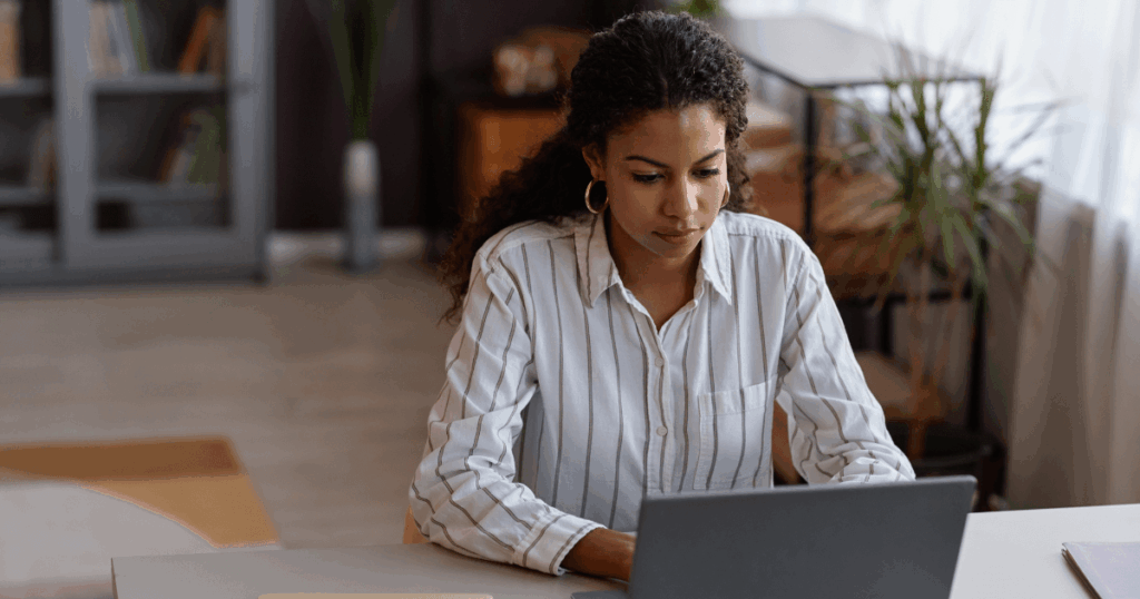 Mulher trabalhando em um notebook em ambiente de escritório, pesquisando informações sobre incentivos fiscais para empresas.