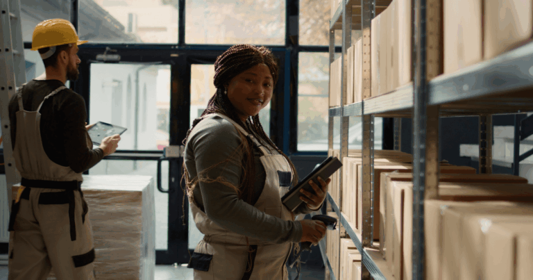 Colaboradores em armazém realizando inventário rotativo, conferindo caixas nas prateleiras com uso de tablet e coletor de dados.