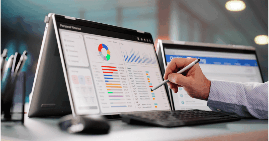 Profissional analisando dashboards financeiros em notebook e tablet, com gráficos e indicadores na tela, representando a visualização e análise de relatório de despesas para controle e tomada de decisão financeira.