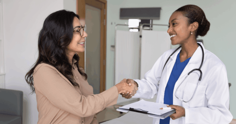 Profissional de saúde ocupacional cumprimentando paciente durante atendimento clínico, representando cuidado com a saúde e bem-estar no ambiente de trabalho.