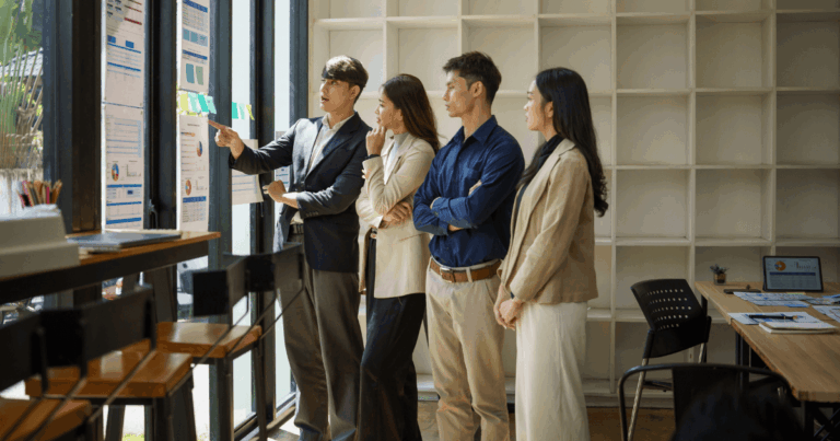 Equipe de profissionais analisando gráficos e indicadores em uma sala de reunião moderna, destacando estratégias de competitividade empresarial e tomada de decisões baseada em dados.