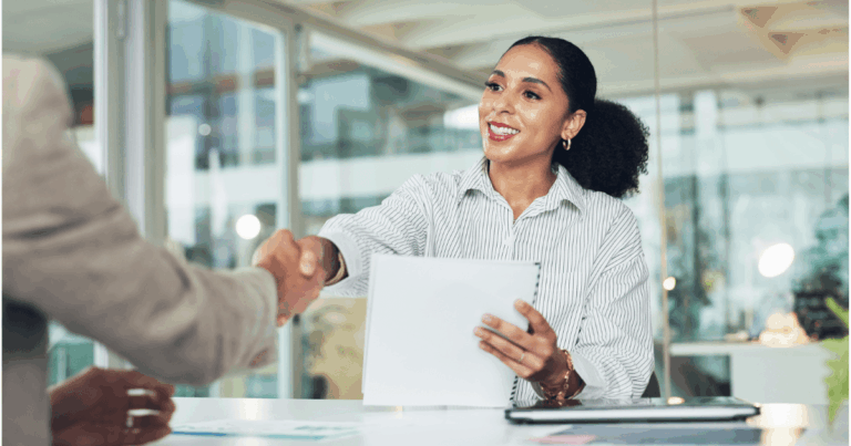 Profissional de RH cumprimentando candidata durante entrevista de recrutamento inteligente em ambiente corporativo.