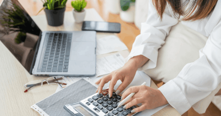 Profissional utilizando calculadora para controlar o reembolso de despesas corporativas.