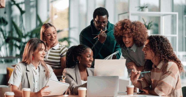 Grupo de profissionais colaborando em uma reunião de aprendizado em ambiente moderno, utilizando notebook, tablet e materiais de apoio. A cena representa os princípios da educação 4.0, com foco em colaboração, desenvolvimento de competências, inovação e integração entre tecnologia e trabalho em equipe.