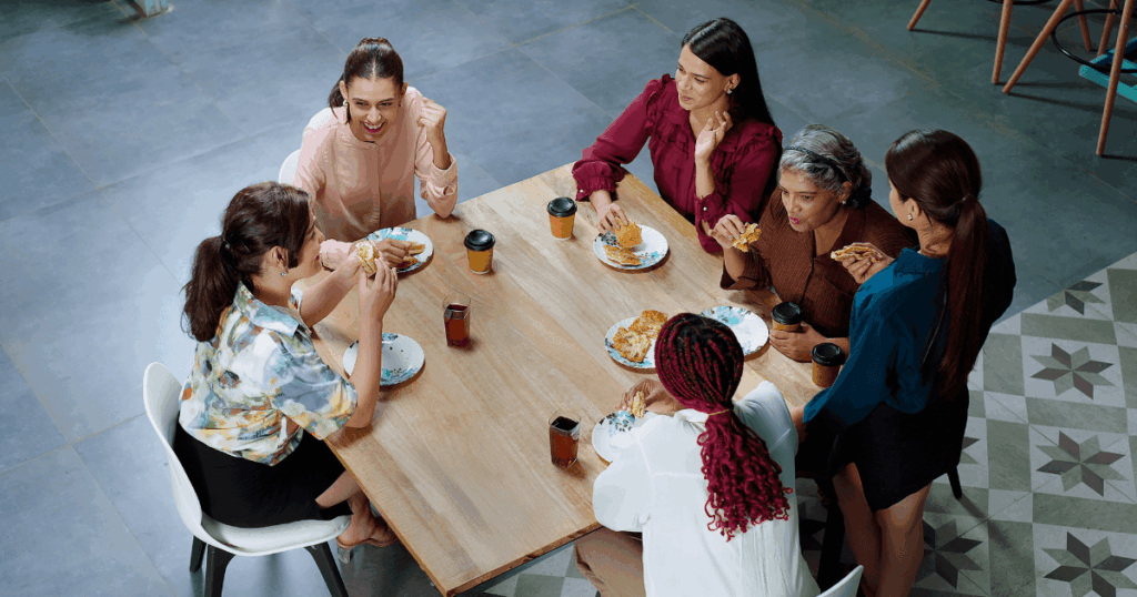 Grupo de mulheres fazendo uma pausa para refeição, representando o PAT, Programa de Alimentação do Trabalhador, e seus benefícios para a qualidade de vida no trabalho